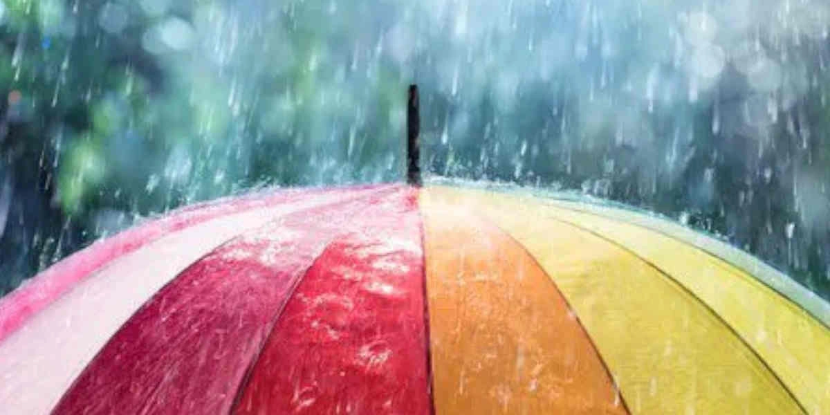 Colorful umbrella with red, orange, yellow, and green panels under heavy rain, symbolizing weather protection and durability