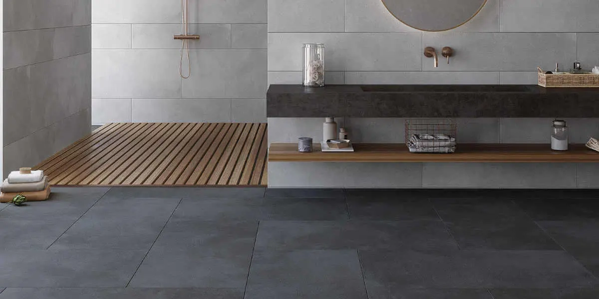 Modernes Badezimmer mit dunklen Bodenfliesen, Holzlatten-Duschboden, schwebendem Waschtisch und rundem Spiegel