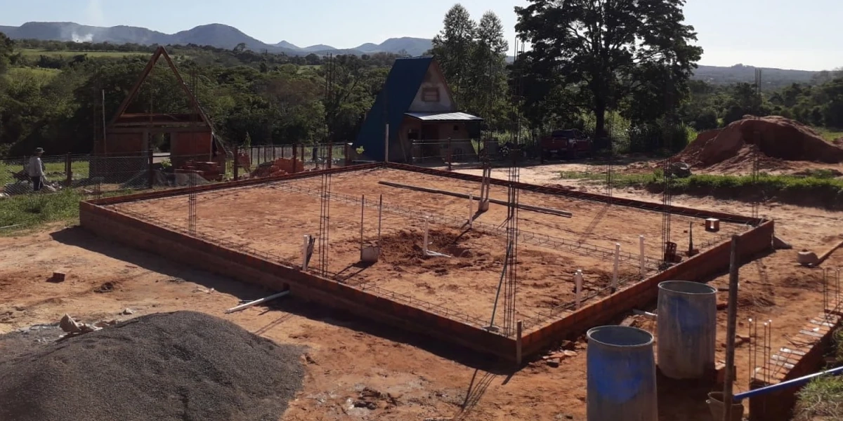 Handaufgegrabene Baugrube in Paraguay mit geflochtenem Bewehrungsstahl und Schalungsrahmen für die Bodenplatte eines Einfamilienhauses